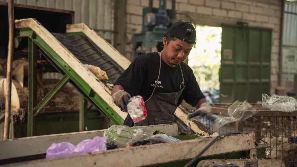 A CleanHub worker sorting collected plastic at the Nusabersih Material Recovery Facility in Jepara